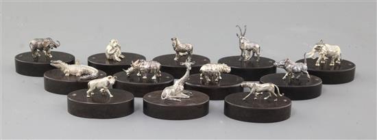 A set of twelve silver menu holders by Patrick Mavros in the form of African wild animals on hardwood bases (in three boxes),
